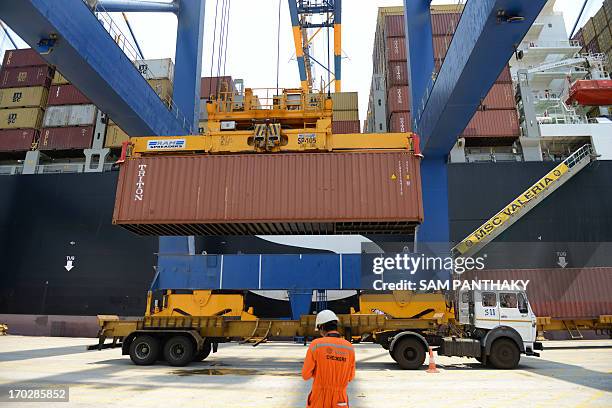 This picture taken on June 4, 2013 shows an Indian truck driver as a container is unloaded from the Container Ship MSC Valeria at Adani Ports and...