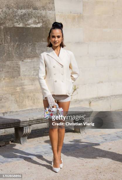 Anna Rosa Vitiello wears creme white double breasted blazer, gloves, shorts, bag with print outside Dior during the Womenswear Spring/Summer 2024 as...