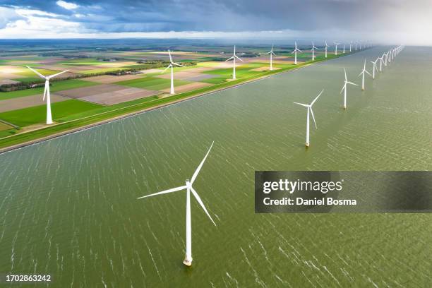 aerial photo of rows of wind turbines along the coast - flevoland stock pictures, royalty-free photos & images