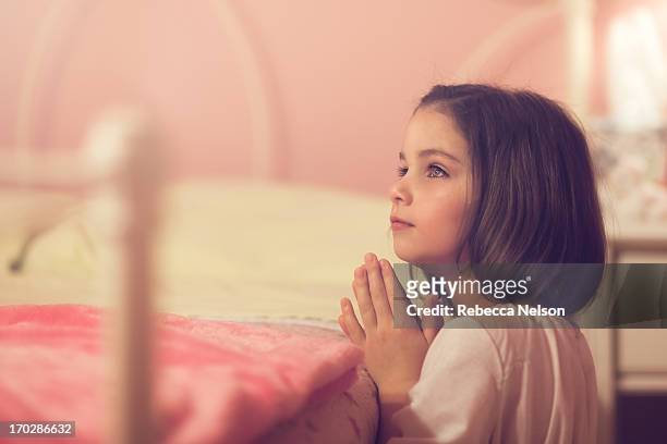 little girl saying her bedtime prayers - children praying stock pictures, royalty-free photos & images