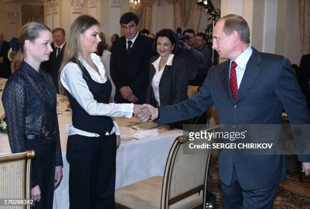 Russian President Vladimir Putin shakes hands with famous Russian gymnasts Alina Kabayeva and Svetlana Khorkina during the meeting with sportsmen,...