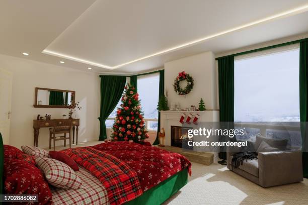 modern bedroom interior with christmas tree, ornaments, double bed, fireplace and armchairs in a chalet - bedding stock pictures, royalty-free photos & images