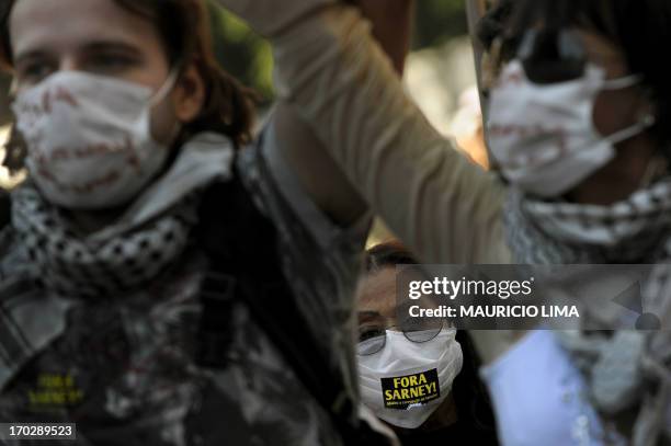 Extreme left activists wearing masks demand the resignation of Brazil's Senate president Jose Sarney while conducting a march, as part of a...