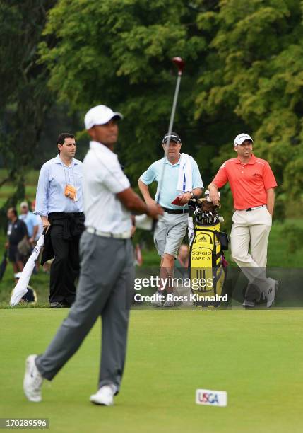 Tiger Woods of the United States hits a shot on the 14th teeas Sergio Garcia of Spain looks on during a practice round prior to the start of the...