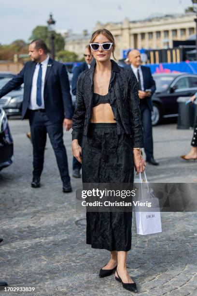 Olivia Palermo wears black top, jacket, pants, white sunglasses outside Dior during the Womenswear Spring/Summer 2024 as part of Paris Fashion Week...