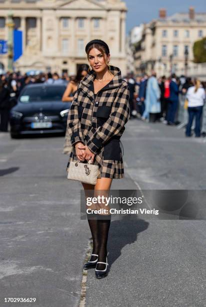 Negin Mirsalehi wears black beige checkered jacket, bag, knee high socks outside Dior during the Womenswear Spring/Summer 2024 as part of Paris...