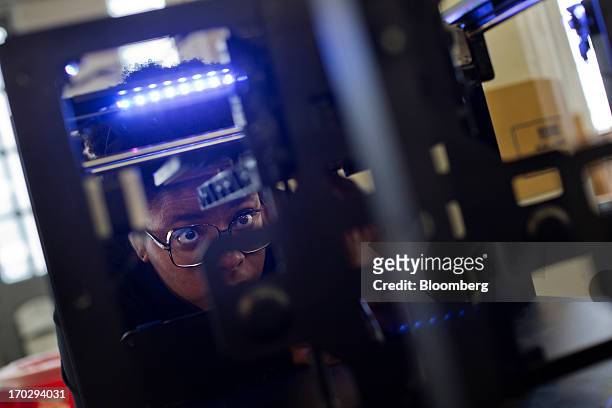Employee Adjua Greaves assembles a Makerbot Industries LLC 3D Printer at the company's new factory in the Brooklyn borough of New York, U.S., on...