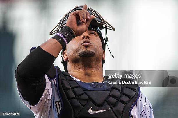 Yorvit Torrealba of the Colorado Rockies points to the sky as part of his pre-game routine before a game against the San Diego Padres at Coors Field...