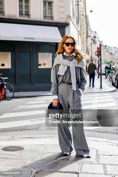 Influencer Alexandra Lapp, wearing a Seidensticker blouse in white, Rossi pinstriped pants in grey, a H&M cashmere sweater in grey, a Allude knit...