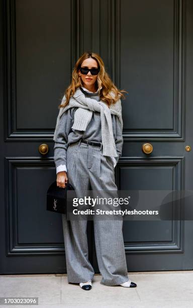 Influencer Alexandra Lapp, wearing a Seidensticker blouse in white, Rossi pinstriped pants in grey, a H&M cashmere sweater in grey, a Allude knit...