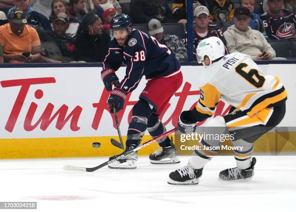 Boone Jenner of the Columbus Blue Jackets passes the puck past Mark Pysyk of the Pittsburgh Penguins during the second period at Nationwide Arena on...