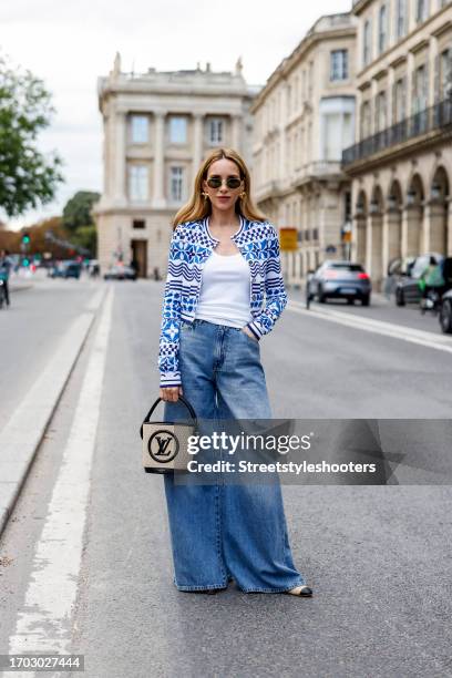 Influencer Alexandra Lapp, wearing wide leg jeans from Zara, a Louis Vuitton bag, a Louis Vuitton cardigan and Louis Vuitton earrings, Chanel...