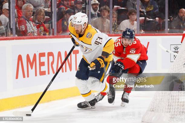 Luke Coughlin of the Florida Panthers pursues Tye Felhaber of the Nashville Predators as he skates with the puck behind the net during a preseason...