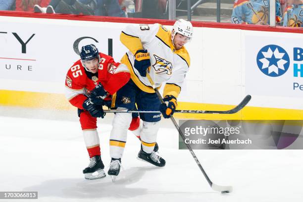 Luke Coughlin of the Florida Panthers attempts to take the puck from Yakov Trenin of the Nashville Predators during a preseason game at the Amerant...