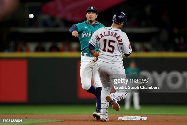 Josh Rojas of the Seattle Mariners makes a play past Martin Maldonado of the Houston Astros at T-Mobile Park on September 25, 2023 in Seattle,...