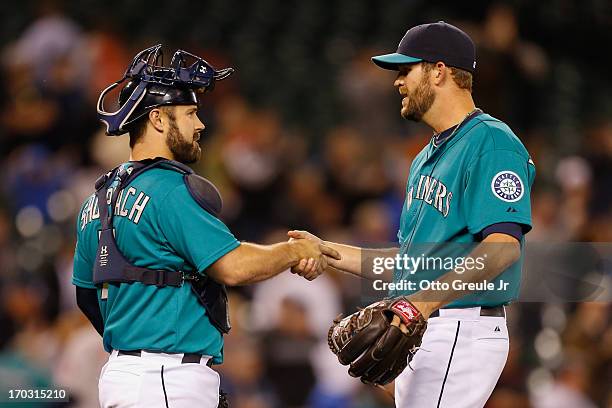 Closing pitcher Tom Wilhelmsen of the Seattle Mariners is congratulated by catcher Kelly Shoppach after defeating the Houston Astros 3-2 at Safeco...