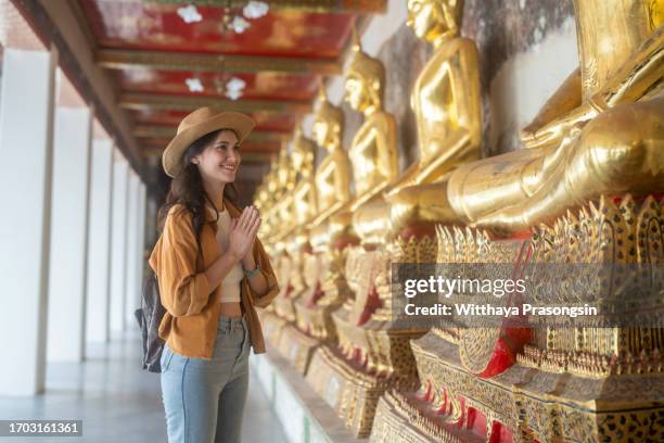 female visiting the cloister with large group of seated buddha images in wat pho temple,bangkok old city, thailand - zen sable stock pictures, royalty-free photos & images