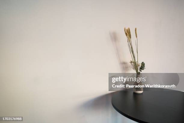 dry flower in the ceramic vase on the circle round black coffee table. - profumeria foto e immagini stock