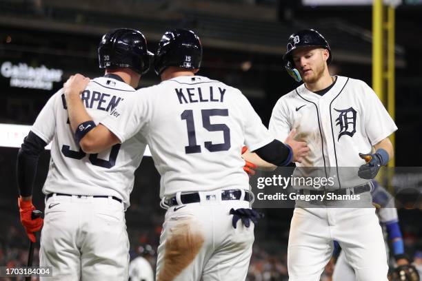 Parker Meadows of the Detroit Tigers celebrates scoring a run in the sixth inning with Carson Kelly and Kerry Carpenter while playing the Kansas City...