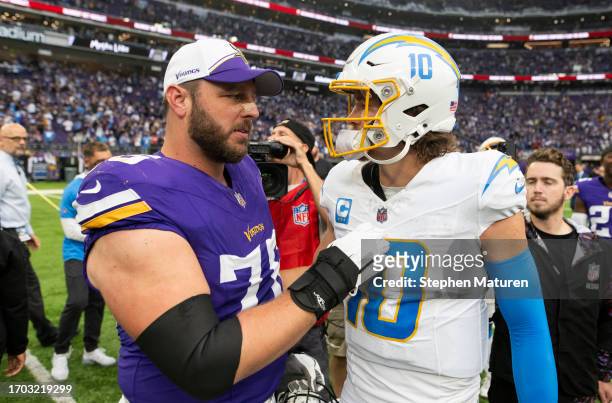 Justin Herbert of the Los Angeles Chargers greets David Quessenberry of the Minnesota Vikings after the game at U.S. Bank Stadium on September 24,...