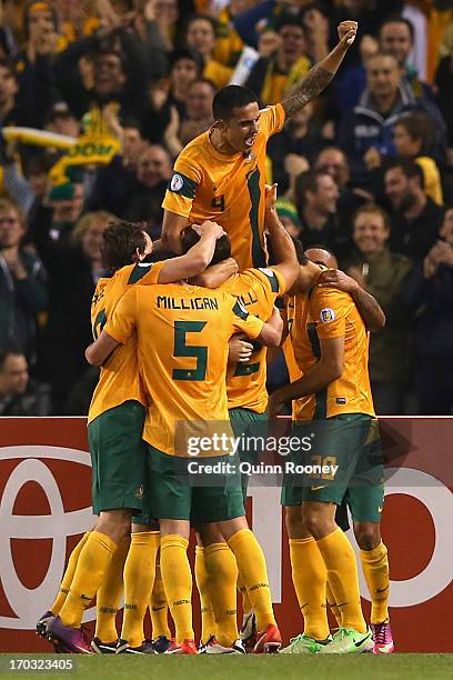Lucas Neill of Australia is congratulated by team mates after scoring a goal during the FIFA World Cup Qualifier match between the Australian...