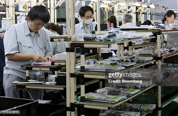 Workers assemble Panasonic Corp.'s Let's Note laptop computers on the production line at the company's plant in Kobe City, Hyogo Prefecture, Japan,...