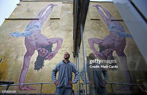 Artist Cosmo Sarson stands besides a giant mural of Jesus breakdancing that he has painted on the 8.5 metre wall beside The Canteen in Stokes Croft...