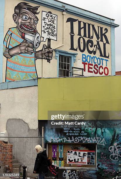 People pass graffiti close to artist Cosmo Sarson's mural of Jesus breakdancing that he has painted on the 8.5 metre wall beside The Canteen in...