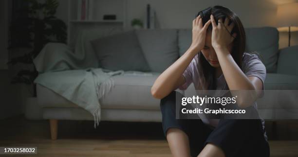 sad depressed young asian woman sitting alone on the floor in the living room - dismissal cricket stock pictures, royalty-free photos & images