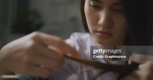 depressive unglückliche kranke junge asiatische frau, die haare hält - dismissal cricket stock-fotos und bilder