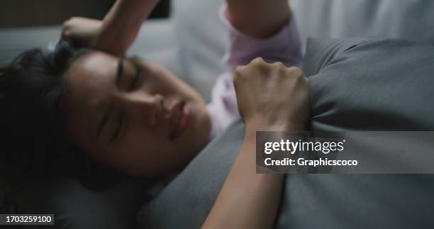 depressed unhappy ill young asian woman lying on couch, suffering from headache - dismissal cricket stock pictures, royalty-free photos & images