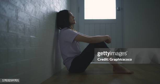 sad depressed young asian woman sitting alone on the floor at home - dismissal cricket stock pictures, royalty-free photos & images