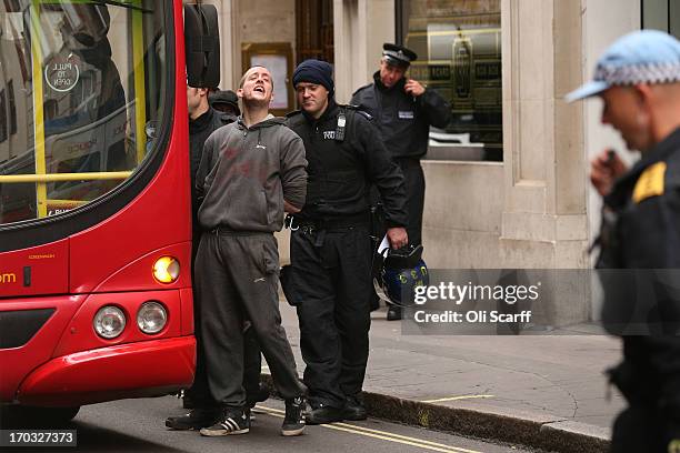 Activist is detained by police and put onto a bus on Golden Square after they occupied a convergence centre of the Stop G8 protest group off Beak...