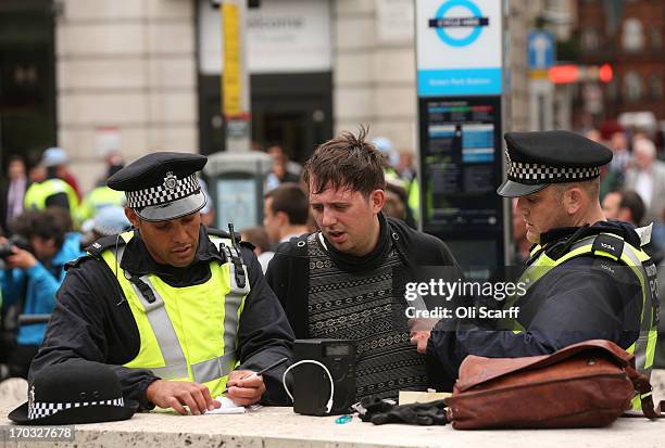 Man is questioned by police on Piccadilly after activists occupied a convergence centre of the Stop G8 protest group off Beak Street ahead of next...