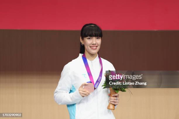 Bronze medalist Zaynab Dayibekova of Uzbekistan celebrates on the podium after the Women's Sabre Individual final march during the 19th Asian Games...