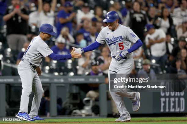 Freddie Freeman of the Los Angeles Dodgers is congratulated by Dino Ebel as he circles the bases after hitting a home run against the Colorado...