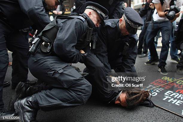 Protester is detained on Oxford Street as part of a protest ahead of next week's G8 summit in Northern Ireland on June 11, 2013 in London, England....