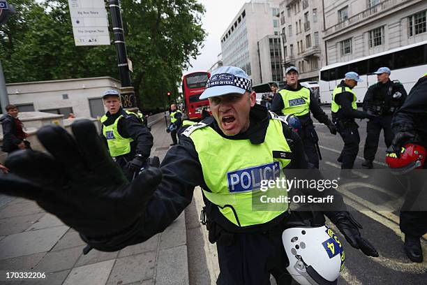 Police officers hold back protesters on Piccadilly during a demonstration ahead of next week's G8 summit in Northern Ireland on June 11, 2013 in...