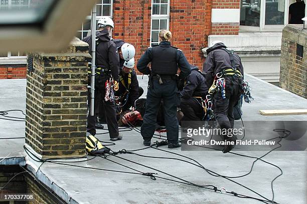 Protester is detained after a precarious rooftop confrontation in Beak Street as arrests are reportedly made as activists occupy a convergence centre...