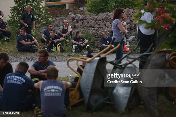 Firemen take a break from stacking sandbags to protect local homes from the spreading floodwaters of the Elbe river on June 11, 2013 in Wust,...