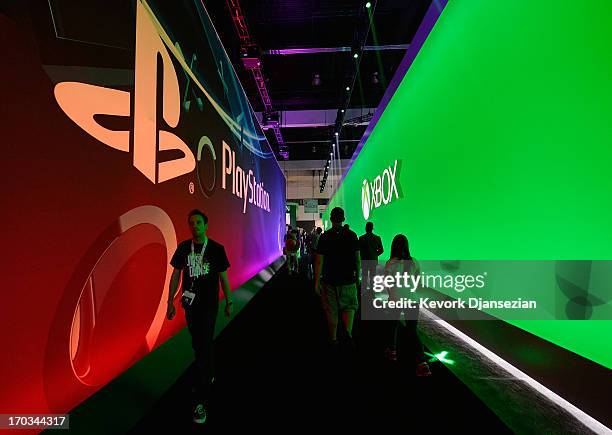 Gamers walk in between Sony Playstation and Ebox booths during the Electronics Expo 2013 at the Los Angeles Convention Center on June 11, 2013 in Los...