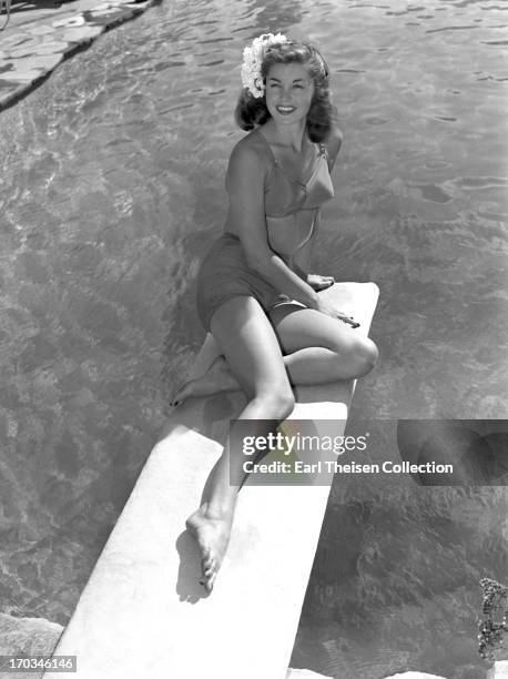 Swimming champion and future movie star Esther Williams poses for a portrait on the diving board of the pool at the Beverly Hills Hotel in 1939 in...
