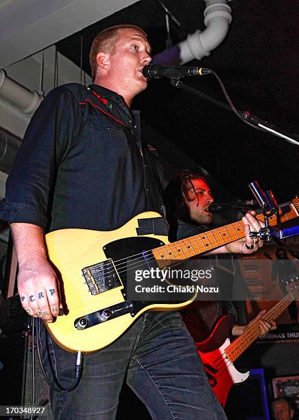 Josh Homme and Michael Shuman of Queens of the Stone Age perform at Rough Trade East on June 11, 2013 in London, England.