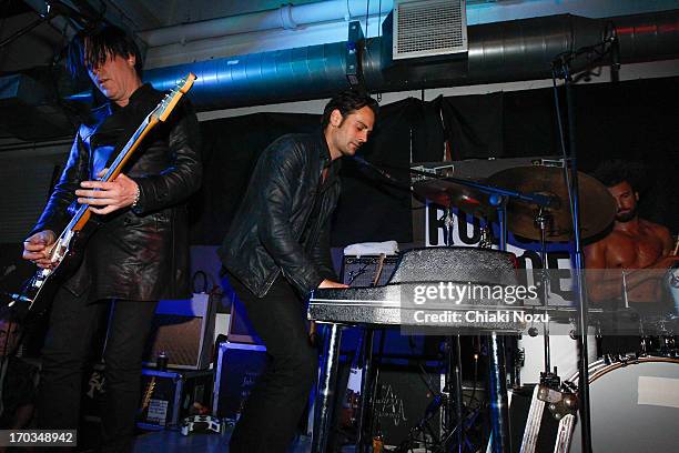 Troy Van Leeuwen and Dean Fertita of Queens of the Stone Age perform at Rough Trade East on June 11, 2013 in London, England.