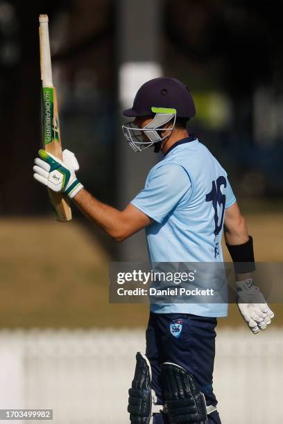 Daniel Hughes of New South Wales raises his bat after making fifty runs during the Marsh One Day Cup match between New South Wales and Tasmania at...