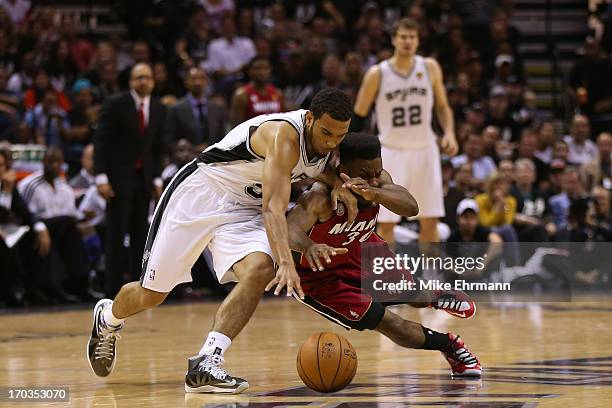 Cory Joseph of the San Antonio Spurs and Norris Cole of the Miami Heat go after a loose ball in the second half during Game Three of the 2013 NBA...