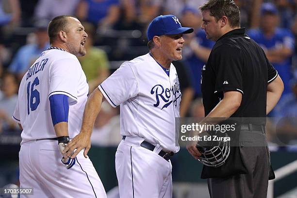 Manager Ned Yost of the Kansas City Royals gets between Billy Butler and plate umpire Jordan Baker after Butler was ejected for arguing strike calls...