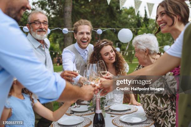 guests at the table are standing and clinking with champagne glasses. - retirement party stock pictures, royalty-free photos & images