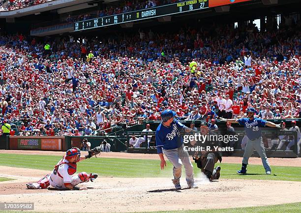 George Kottaras looks on as Geovany Soto of the Texas Rangers shows umpire Bill Miller the ball after tagging out Billy Butler of the Kansas City...