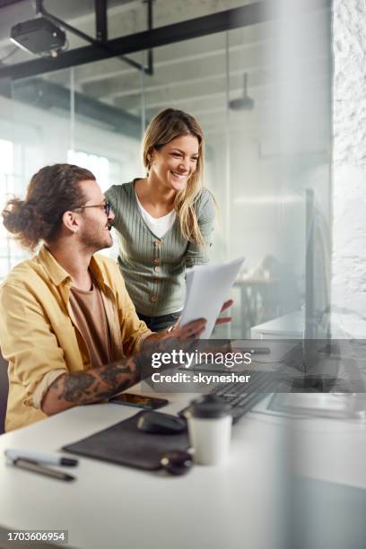 happy programmers working on pc and reports in the office. - grafisch ontwerper stockfoto's en -beelden